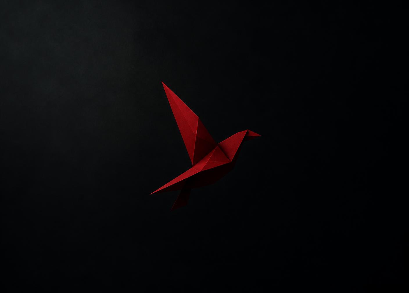 Forme géométrique rouge évoquant un cardinal en vol